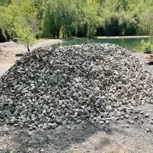 big pile of gravel on landscaping lot with lake in the background