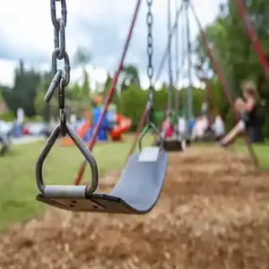 close up of swing set on play ground with kid safe mulch