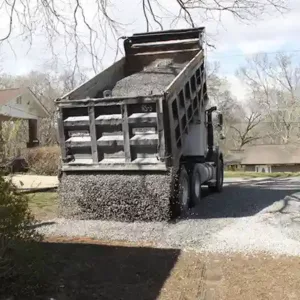 dump truck tailgate spreading preparing to dump load into driveway