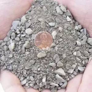 hands holding 1_4 minus gravel texture close up with penny inside for scale